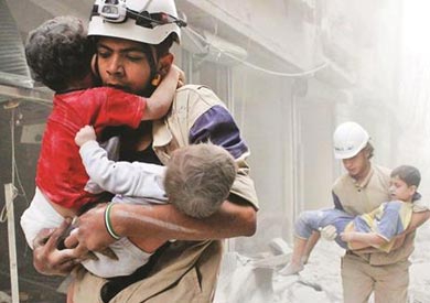 عنصرين من متطوعي" الخوذ البيضاء" ينتشلان أطفال من انقاض منازل دمرتها الغارات في سوريا